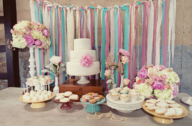 cake dessert display table ribbons hanging macaroons and wedding cake 